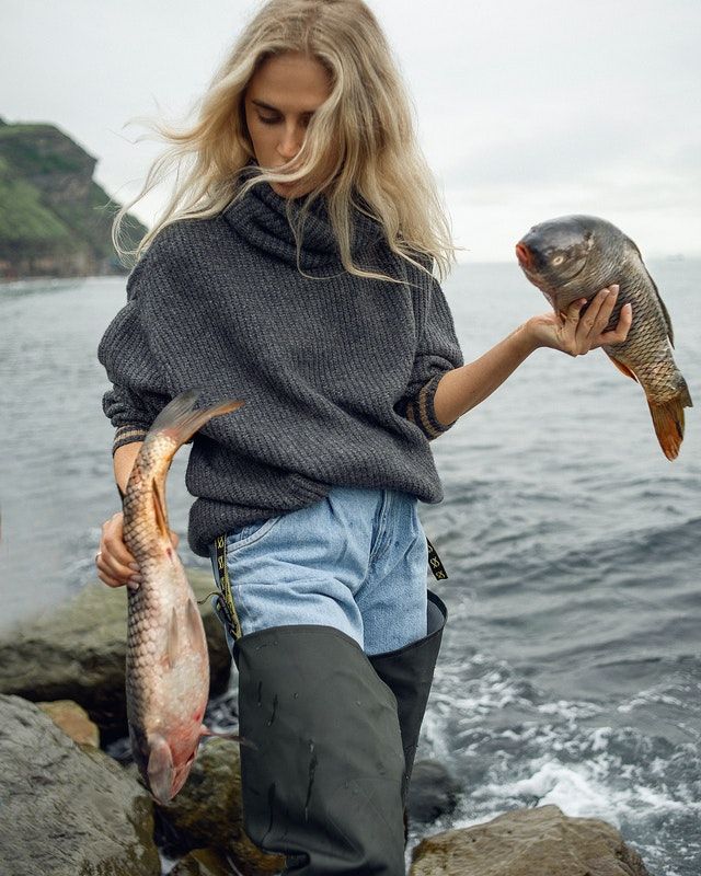 Woman holding two carps